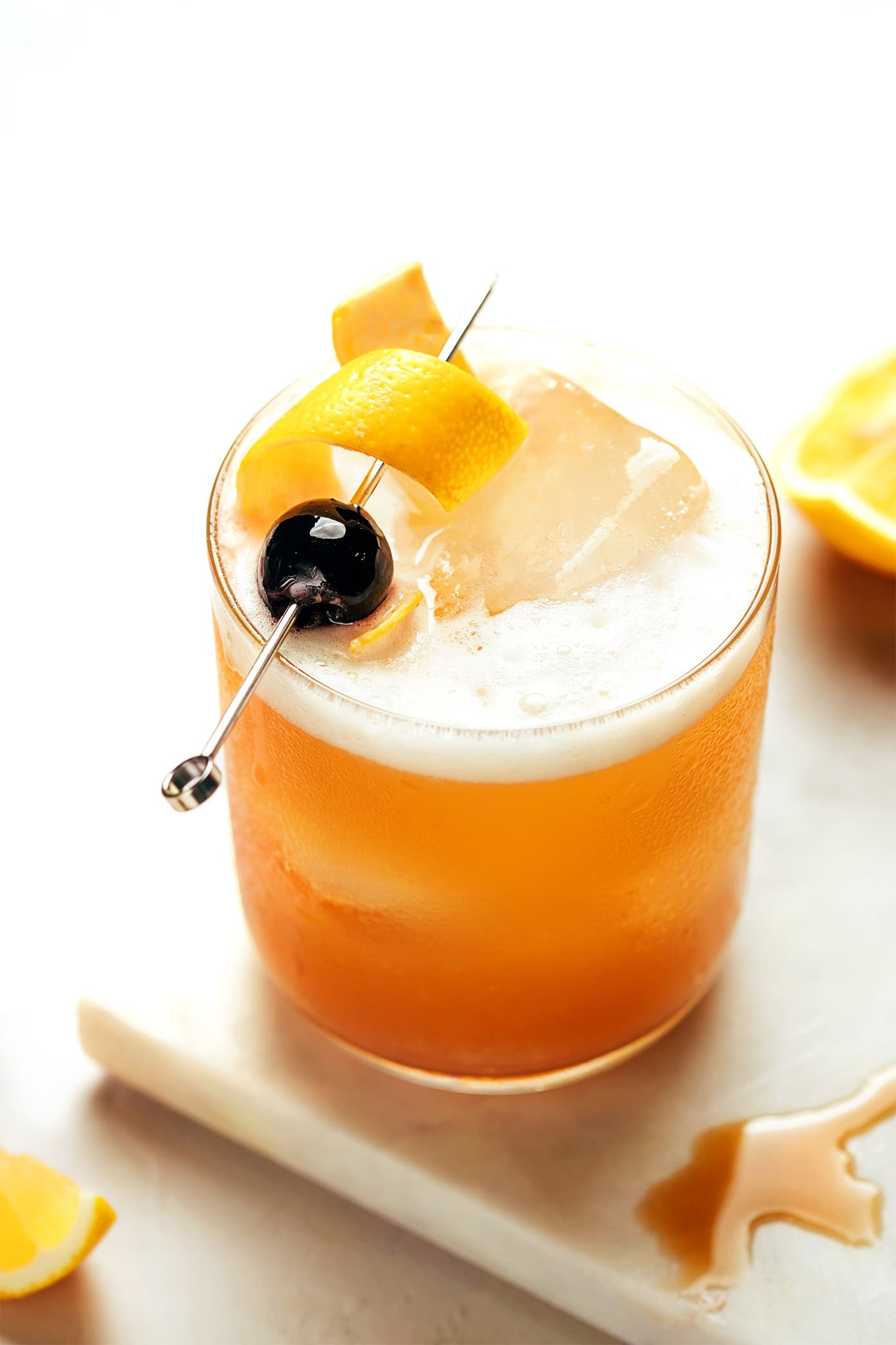 This classic Amaretto Sour recipe is easy to make with bourbon, lemon juice, Amaretto and egg white. Feel free to add additional sweetener or bitters, if you'd like, and garnish with a lemon twist and maraschino cherry. It's always such a cozy and sophisticated cocktail! | gimmesomeoven.com Amaretto Sour