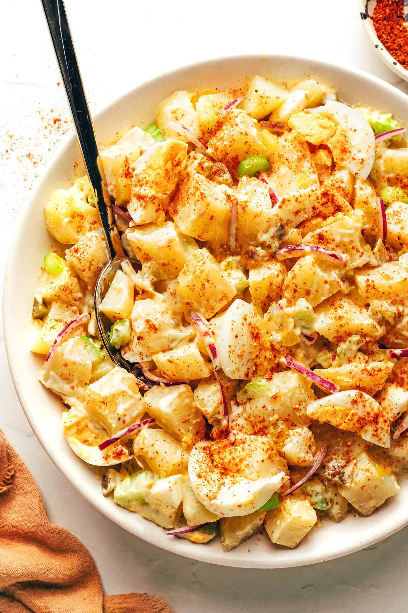 My go-to classic potato salad recipe is easy to make with tender potatoes, hard-boiled eggs, crisp veggies, pickle relish, and a zesty creamy dressing. It's the perfect make ahead side dish for potlucks, picnics and barbecues. And feel free to add some extra bacon or cheese if you'd like! | gimmesomeoven.com Classic potato salad in a bowl with spoon