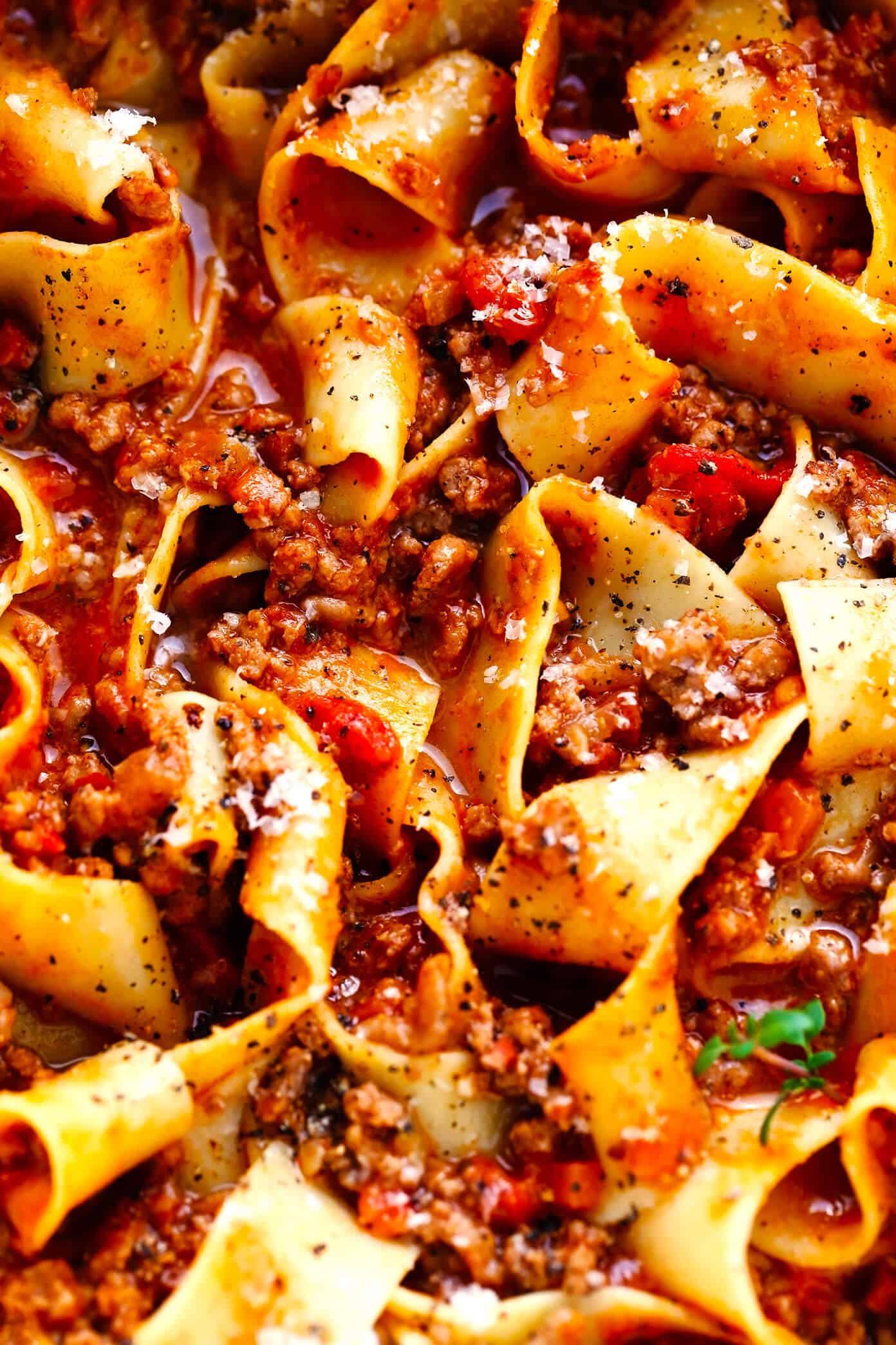 This amazing Bolognese sauce recipe is slow-simmered with a rich tomato base, a delicious blend of beef and pork, and the coziest blend of garlicky herb seasonings. Serve with pasta, gnocchi, or roasted eggplant and enjoy! | gimmesomeoven.com #bolognese #italian #meat #sauce #marinara #pasta #spaghetti #dinner #beef Closeup of Pappardelle Bolognese