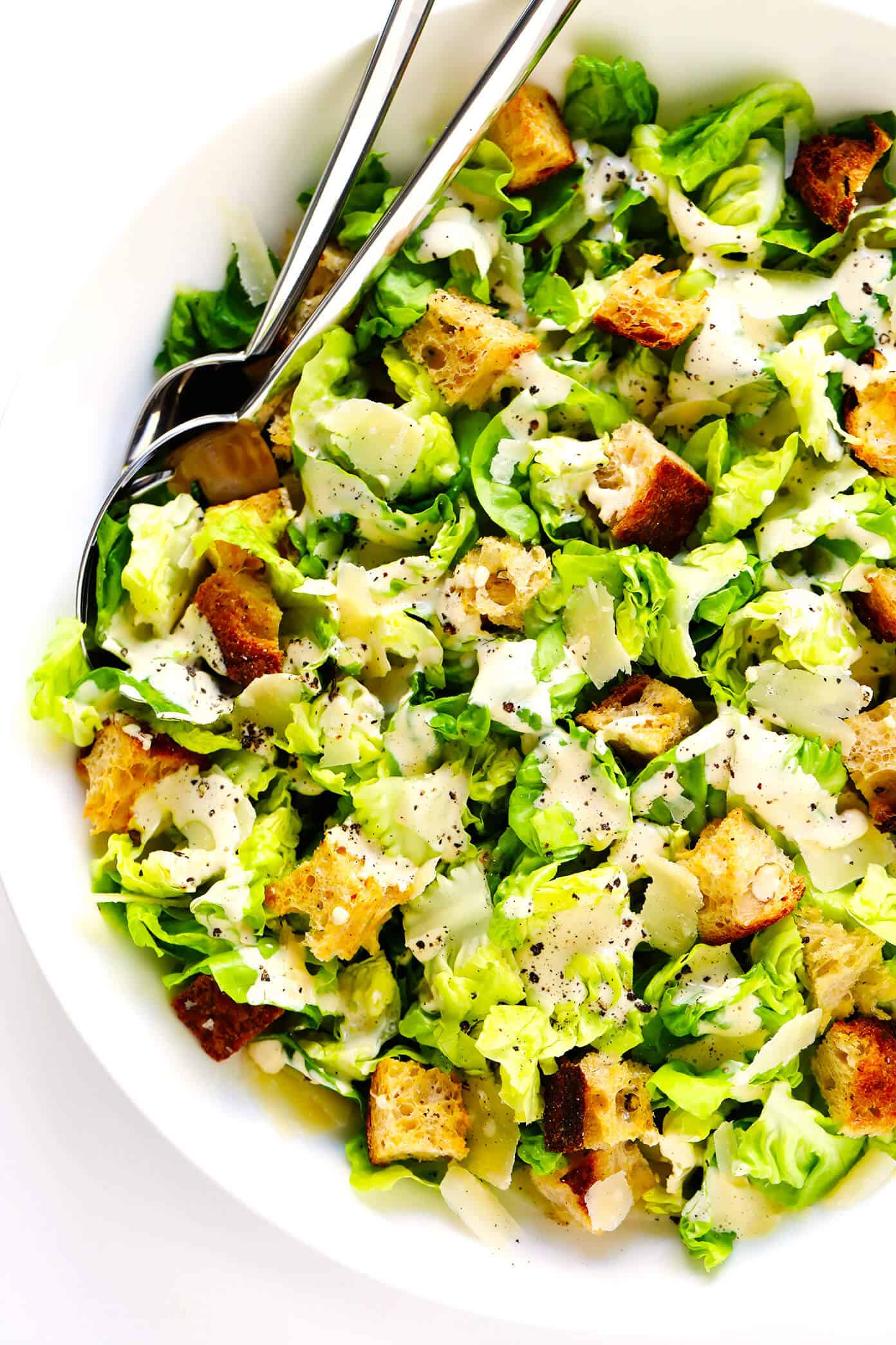 The BEST homemade Caesar salad recipe -- full of crisp lettuce, toasty sourdough croutons, lots of Parmesan cheese, and my all-time favorite homemade Caesar dressing. Feel free to add in some proteins (chicken, shrimp, salmon, etc.) or grill the lettuce too, if you would like! | gimmesomeoven.com #caesar #salad #dressing #homemade #glutenfree #healthy #summer #italian Homemade Caesar Salad with Caesar Dressing Drizzled on Top