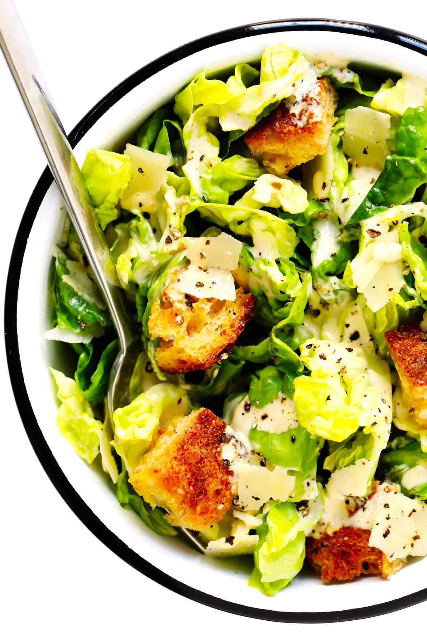 The BEST homemade Caesar salad recipe -- full of crisp lettuce, toasty sourdough croutons, lots of Parmesan cheese, and my all-time favorite homemade Caesar dressing. Feel free to add in some proteins (chicken, shrimp, salmon, etc.) or grill the lettuce too, if you would like! | gimmesomeoven.com #caesar #salad #dressing #homemade #glutenfree #healthy #summer #italian Caesar Salad In Bowl With Croutons and Parmesan