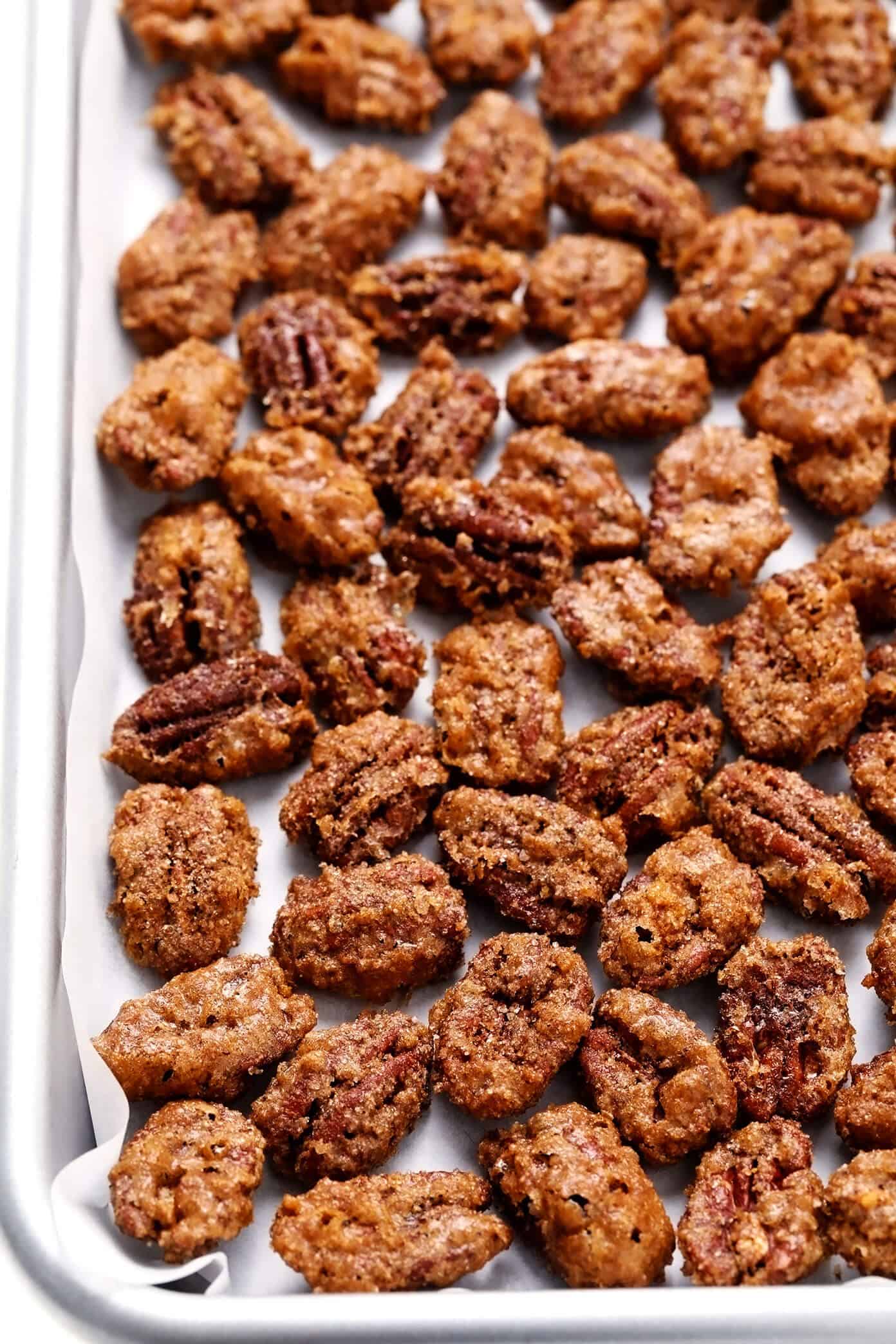 My favorite classic candied pecans recipe is made with a crunchy cinnamon sugar coating that is perfectly seasoned with a hint of sea salt and cayenne. Easy to make with 7 ingredients, naturally gluten-free, and perfect for topping salads, casseroles, yogurt, ice cream and more! | gimmesomeoven.com #candied #pecans #nuts #dessert #salad #topping #glutenfree #candy Candied Pecans on Baking Sheet