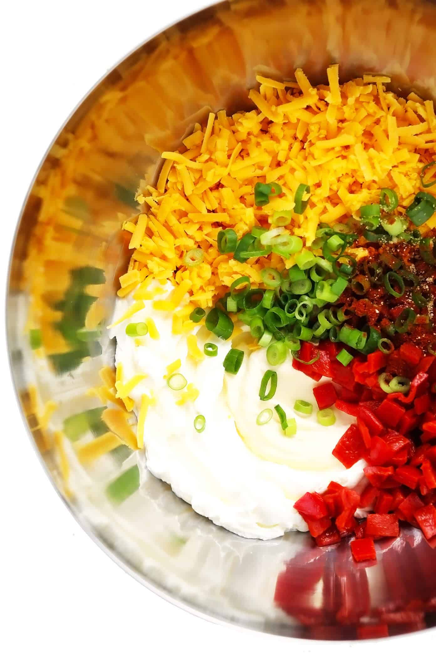 This 10-minute homemade pimento cheese recipe is made with sharp cheddar, tangy cream cheese and mayo, roasted red peppers, fresh green onions, and a zesty blend of seasonings. Serve it as a appetizer dip or spread on sandwiches, burgers, veggies, or whatever sounds good. | gimmesomeoven.com #pimento #pepper #cheese #dip #spread #glutenfree #southern #sandwich Pimento Cheese Ingredients in Mixing Bowl