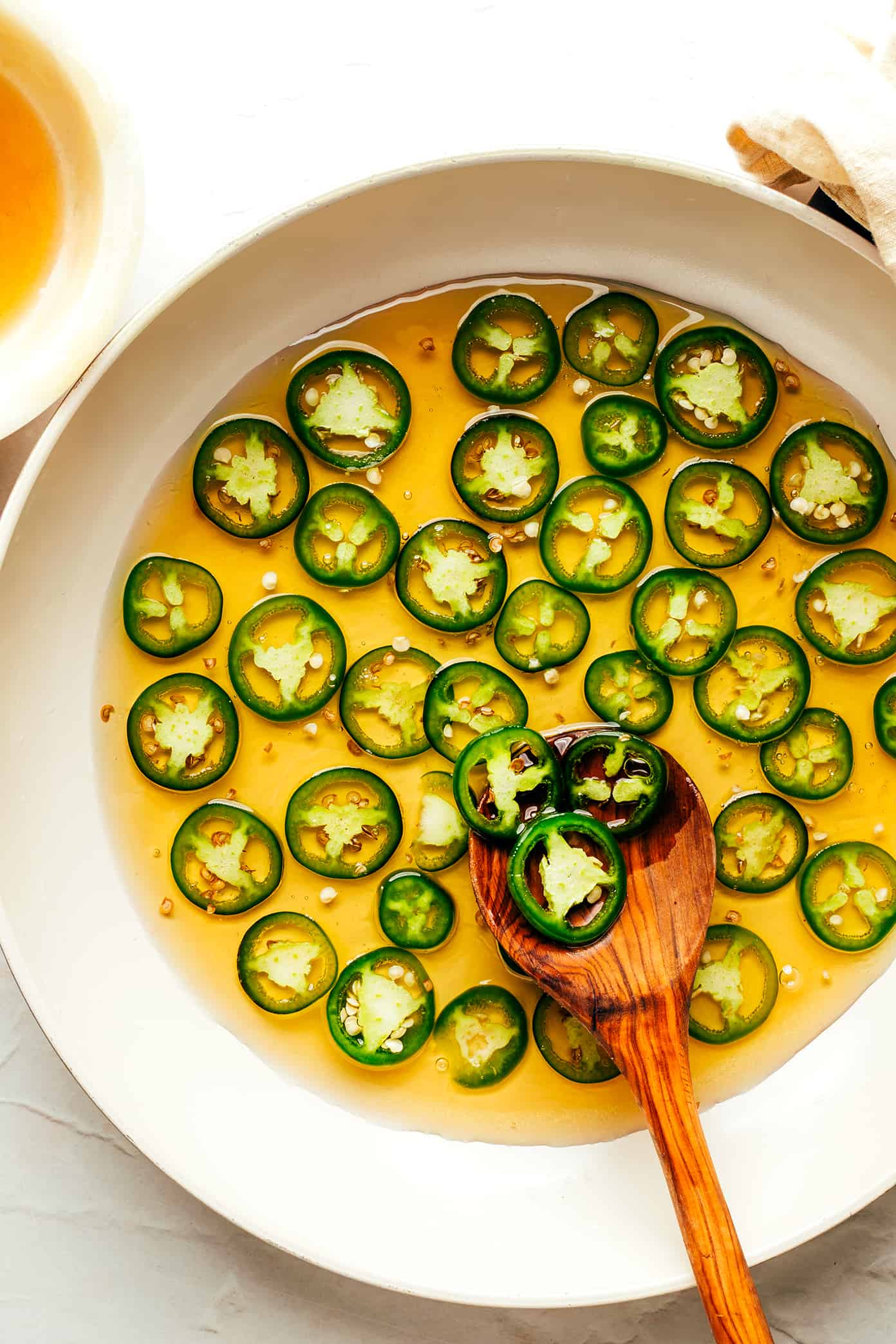 This homemade hot honey recipe is quick and easy to make with 3 ingredients and tastes delicious drizzled on everything from pizza to biscuits, fried chicken, salmon, veggies, baked brie and more! | gimmesomeoven.com Making homemade hot honey with jalapeno peppers