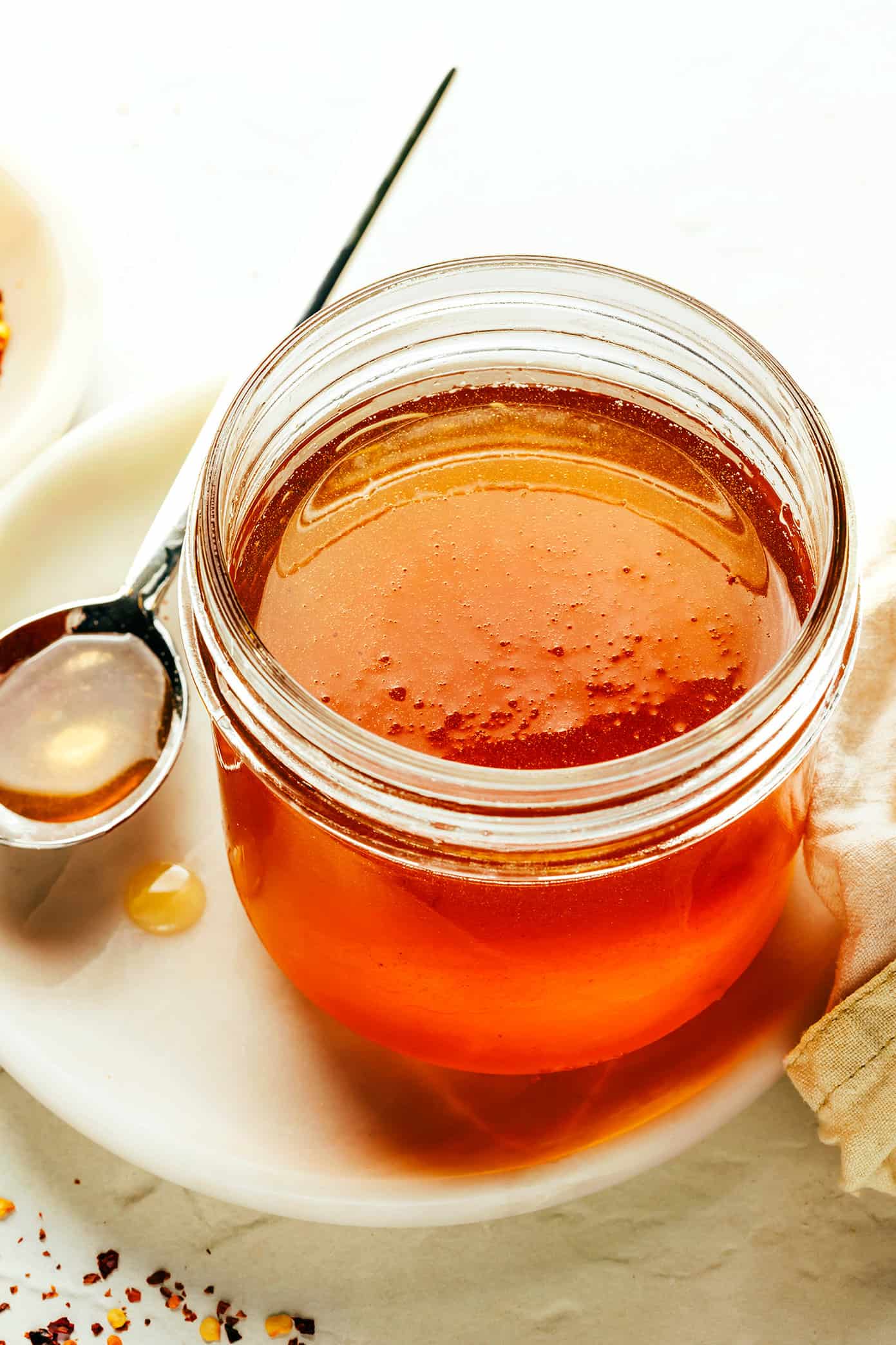 This homemade hot honey recipe is quick and easy to make with 3 ingredients and tastes delicious drizzled on everything from pizza to biscuits, fried chicken, salmon, veggies, baked brie and more! | gimmesomeoven.com Jar of Hot Honey
