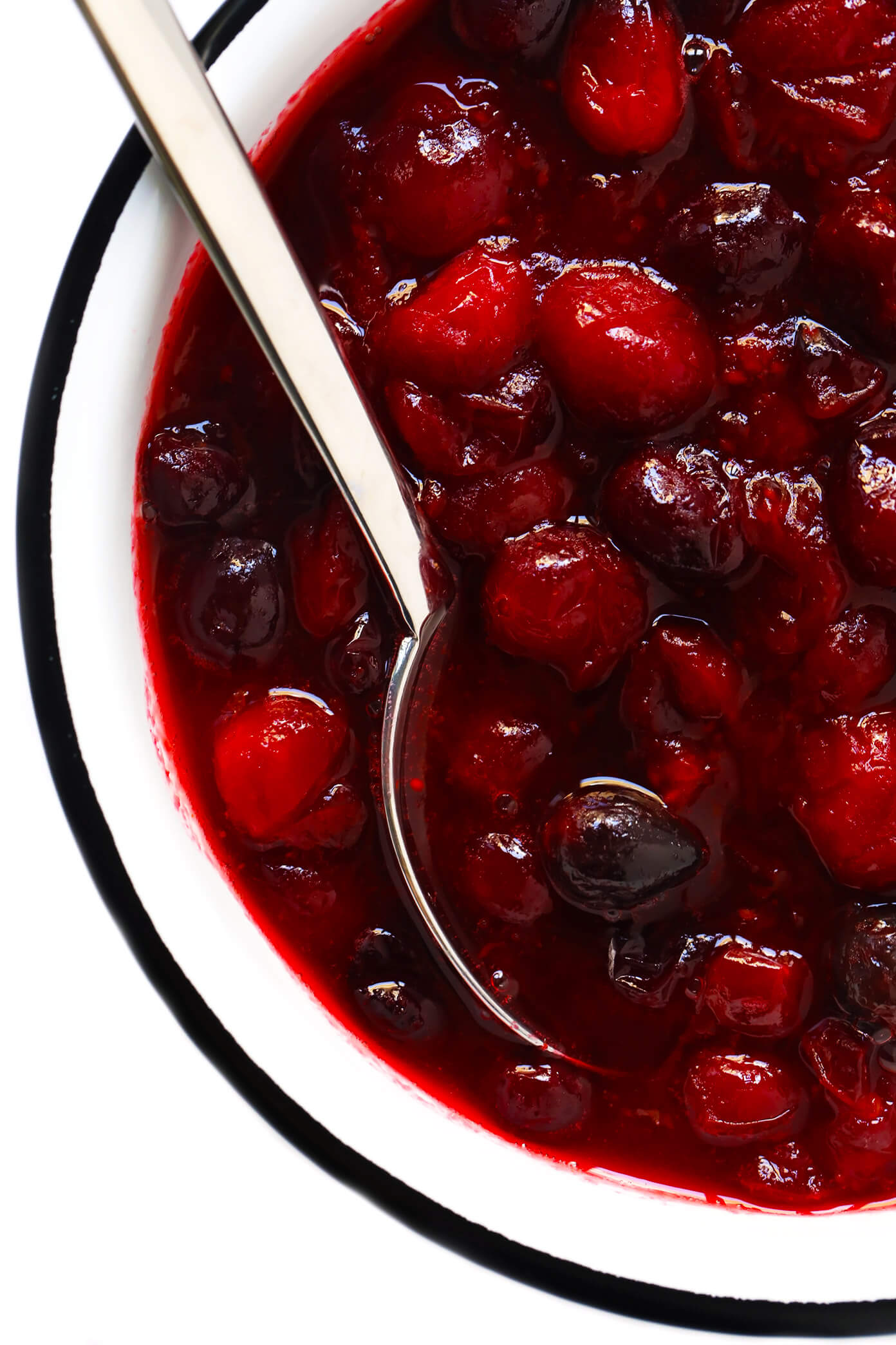 This homemade Maple Cranberry Sauce recipe is naturally-sweetened with real maple syrup, it's easy to make in about 15 minutes, and it's totally delicious. Perfect for Thanksgiving, Christmas, or anytime you'd love an extra pop of color on the dinner table. | Gimme Some Oven #cranberry #sauce #thanksgiving #naturallysweetened #sugarfree #maple #vegan #glutenfree #vegetarian #side #christmas #holiday #dinner Vegan Cranberry Sauce Recipe In Bowl