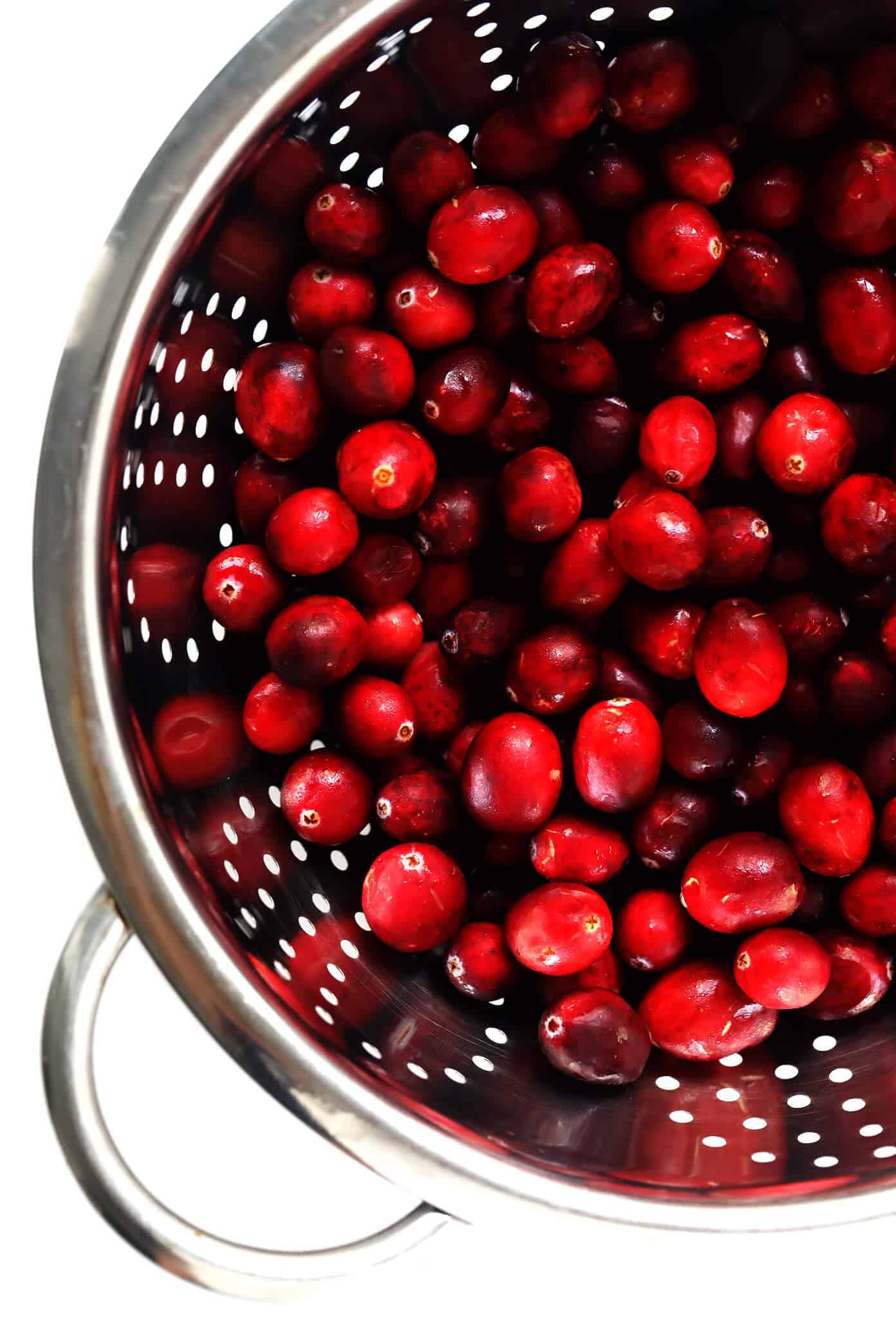 This homemade Maple Cranberry Sauce recipe is naturally-sweetened with real maple syrup, it's easy to make in about 15 minutes, and it's totally delicious. Perfect for Thanksgiving, Christmas, or anytime you'd love an extra pop of color on the dinner table. | Gimme Some Oven #cranberry #sauce #thanksgiving #naturallysweetened #sugarfree #maple #vegan #glutenfree #vegetarian #side #christmas #holiday #dinner Fresh Cranberries in Strainer