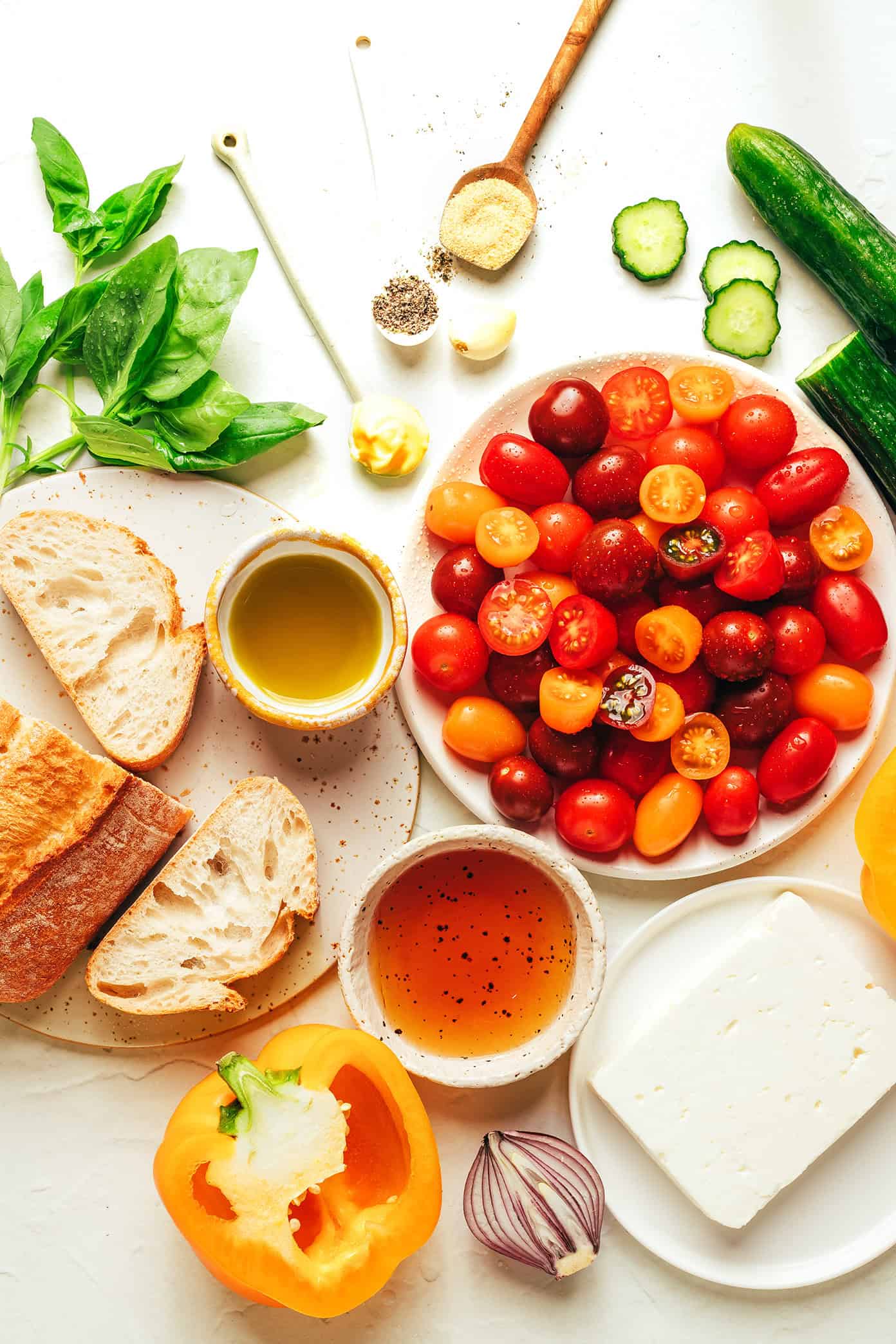 This delicious panzanella salad is easy to make with garlic croutons, fresh cherry tomatoes, cucumber, bell pepper, red onion, feta or mozzarella, and a red wine vinaigrette. The perfect easy dinner recipe for summertime and easy to customize to your liking! | gimmesomeoven.com Panzanella ingredients