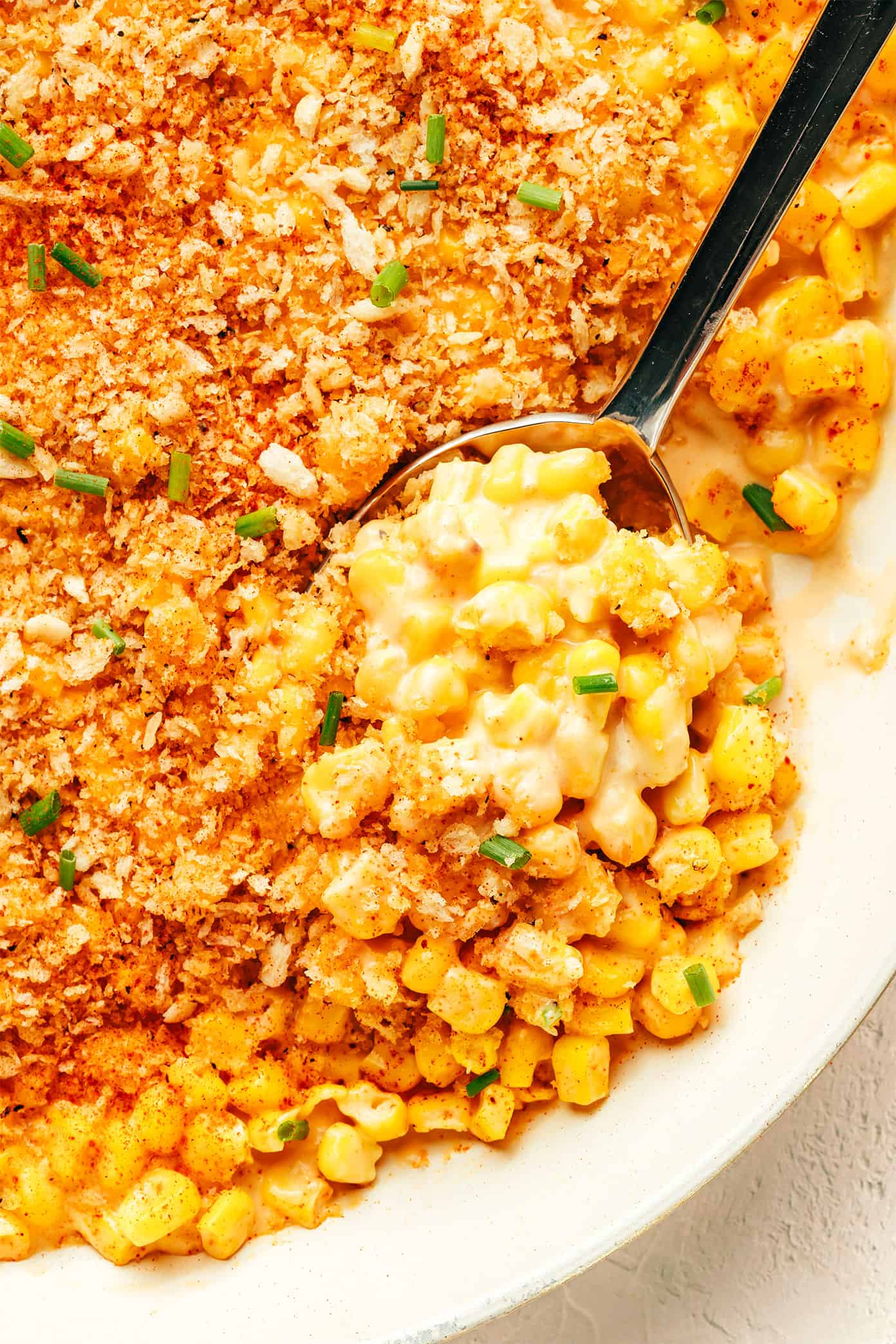 This Parmesan Creamed Corn recipe is layered with sweet and savory flavors, perfectly creamy and cheesy, and sprinkled with irresistible crispy toasted garlic breadcrumbs. Perfect for the holidays, such as Thanksgiving or Christmas, or for any weeknight dinner that needs a simple side dish! | gimmesomeoven.com Parmesan Creamed Corn Closeup with Garlic Breadcrumbs