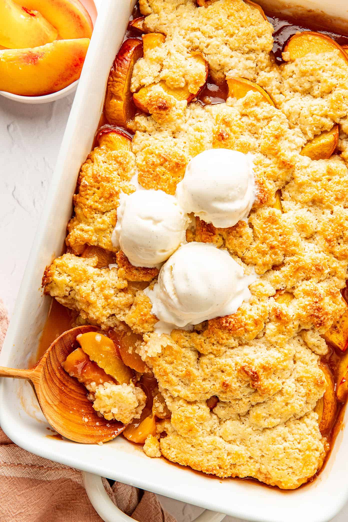 This easy peach cobbler recipe features a juicy cinnamon-vanilla peach filling and a golden buttery biscuit topping -- the perfect dessert to celebrate fresh peach season! | gimmesomeoven.com fresh peach cobbler