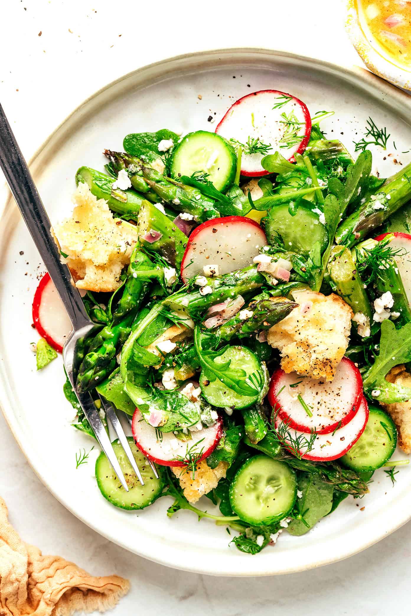 This vibrant spring panzanella salad recipe features crispy sourdough croutons, roasted asparagus, fresh veggies, herbs, feta, and a lemony shallot vinaigrette. | gimmesomeoven.com Spring Panzanella Salad on Plate