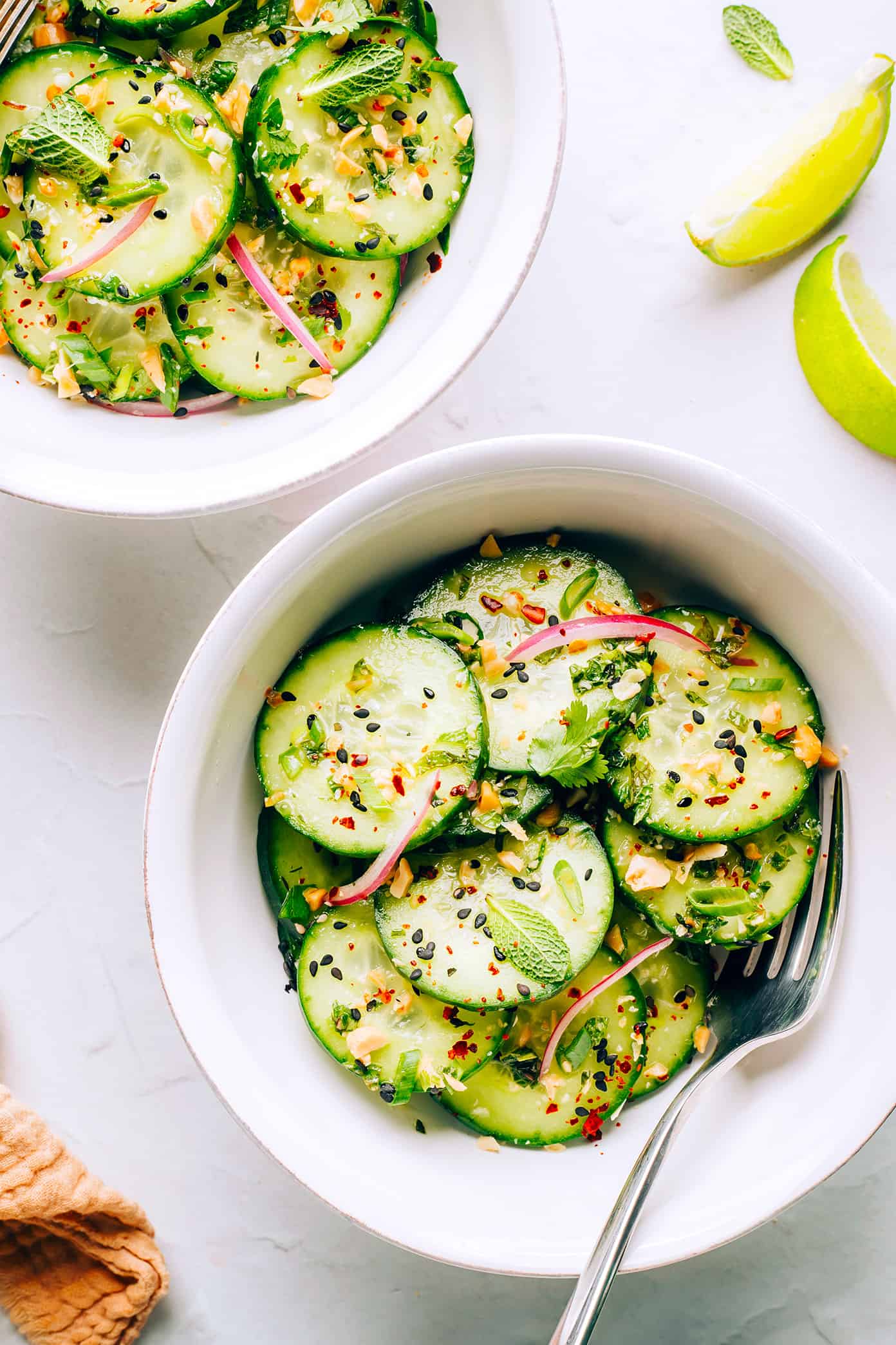 This Thai cucumber salad recipe is loaded up with fresh cucumbers, onions, herbs and peanuts and tossed with a quick zesty lime dressing. It's the perfect cold side dish, and it's naturally gluten-free and can be made vegetarian/vegan too. | gimmesomeoven.com Thai Cucumber Salad in Serving Bowls